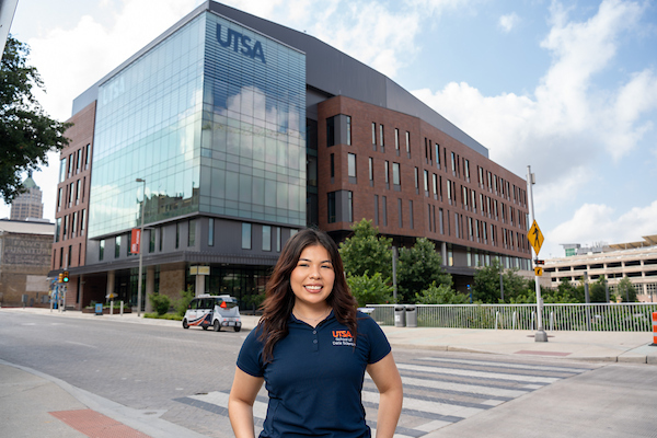 UT San Antonio student standing in front of San Pedro I and The Little Runner.
