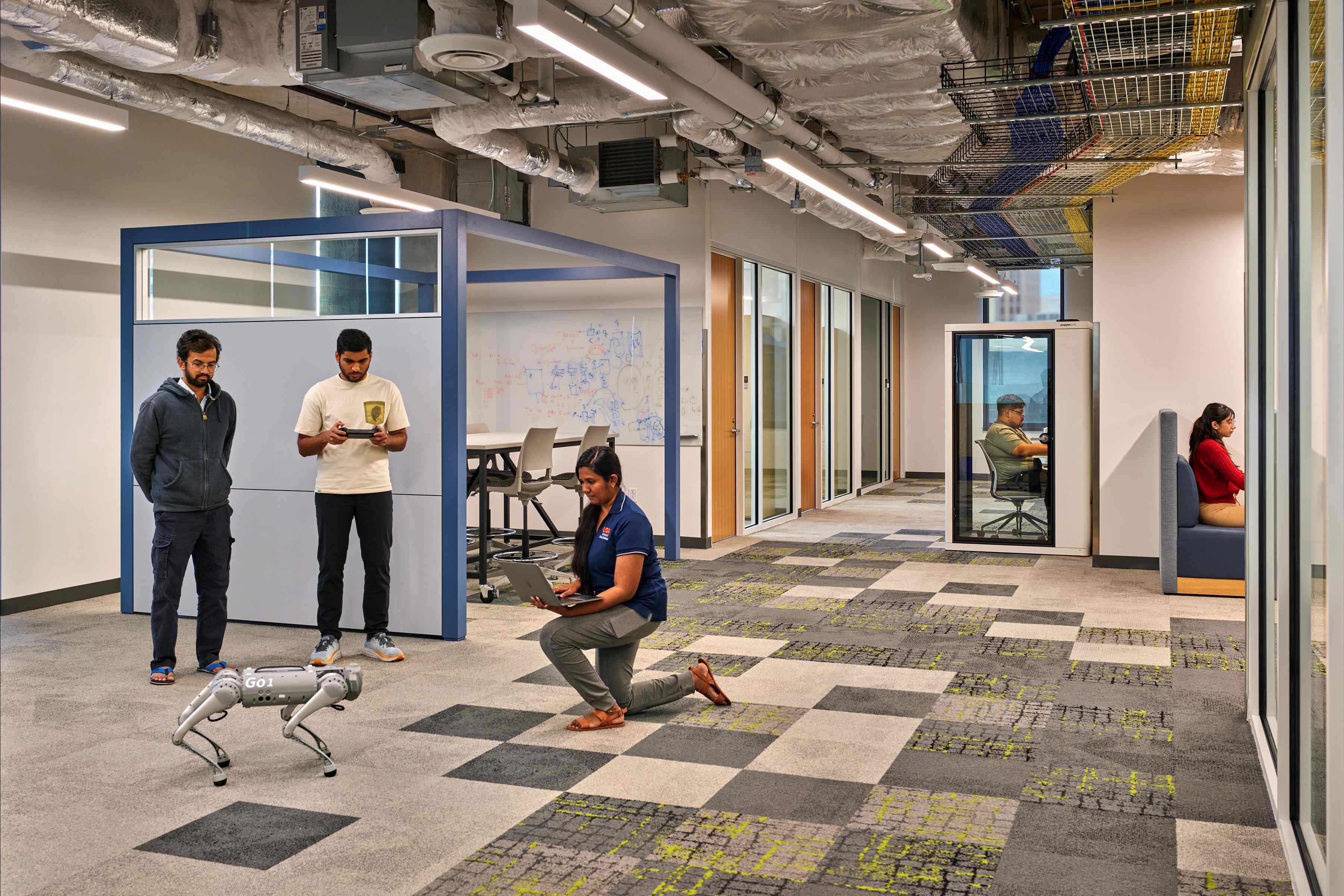 Students working with a robot in an office