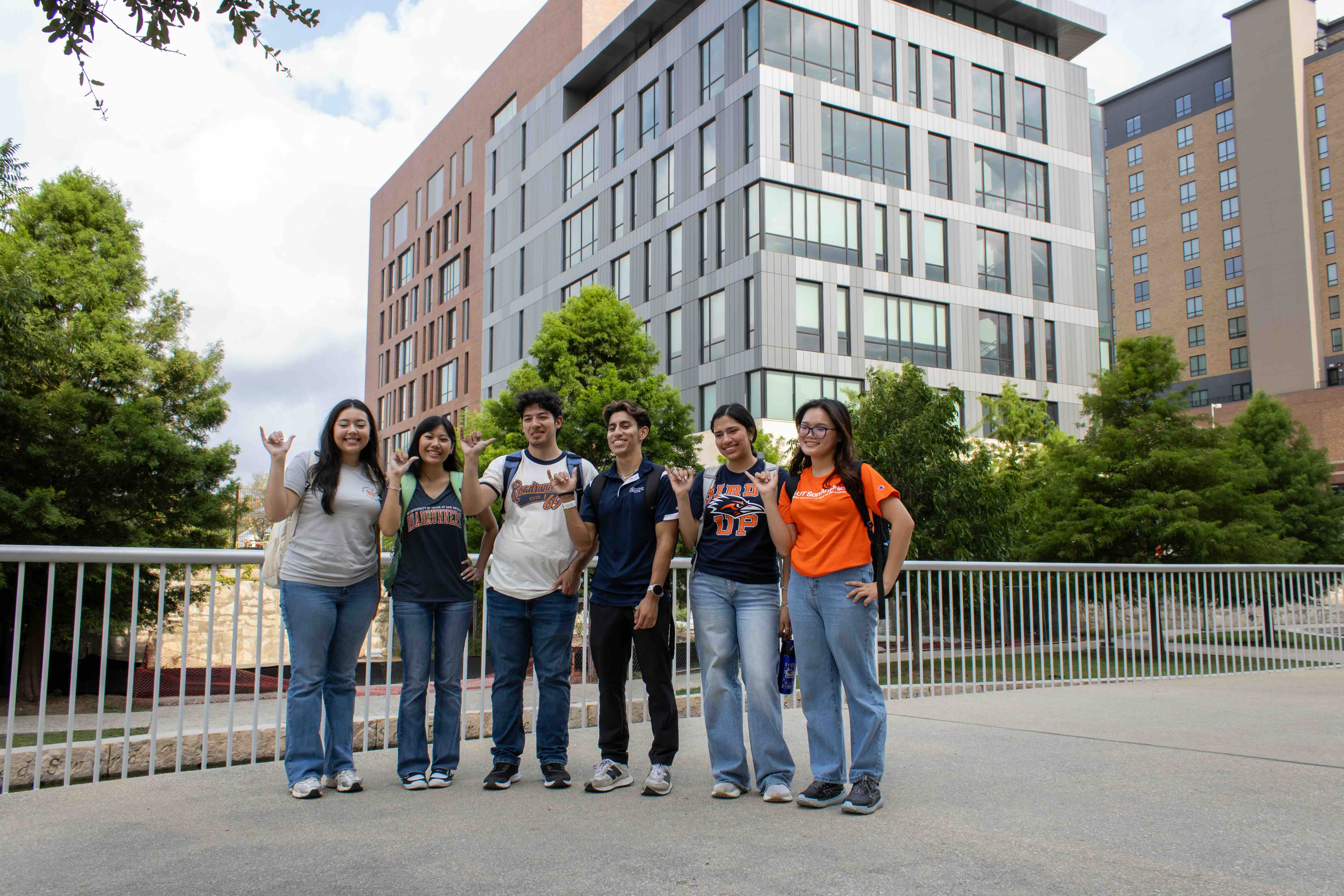 Six students standing along the San Pedro Creek with San Pedro II in the distance.